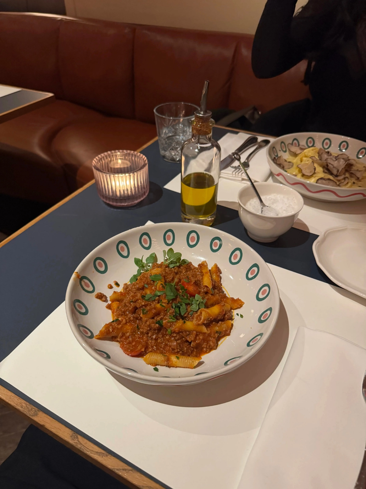 Gedeckter Tisch mit Nudeln und einer Kerze in einem Restaurant